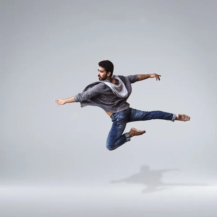 Danseur en saut, jambes tendues, en plein effort artistique.