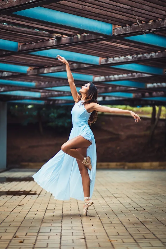 Danseuse en posture concentrée, robe bleue, atelier intimiste.